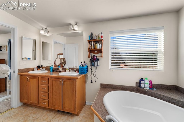 bathroom with tile patterned flooring, vanity, and a bathing tub