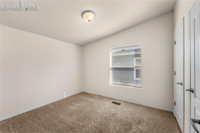 empty room with lofted ceiling and carpet flooring