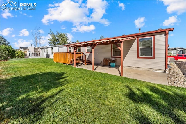 back of property with a lawn and a patio