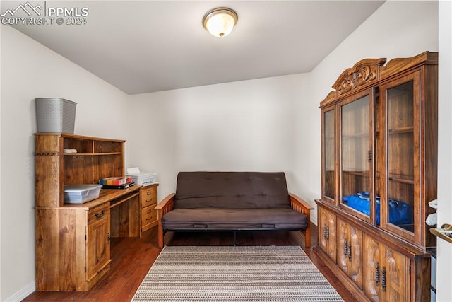 living area featuring vaulted ceiling and dark hardwood / wood-style flooring