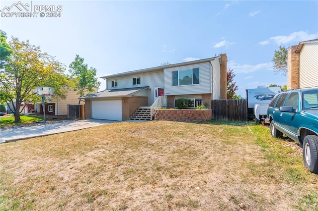 split foyer home featuring a garage and a front lawn