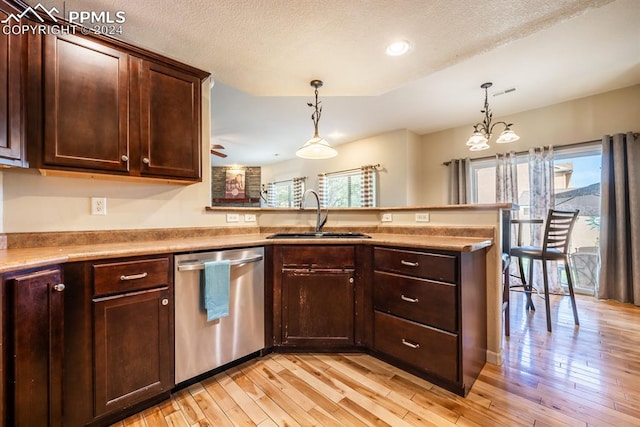 kitchen with stainless steel dishwasher, sink, light hardwood / wood-style flooring, and decorative light fixtures