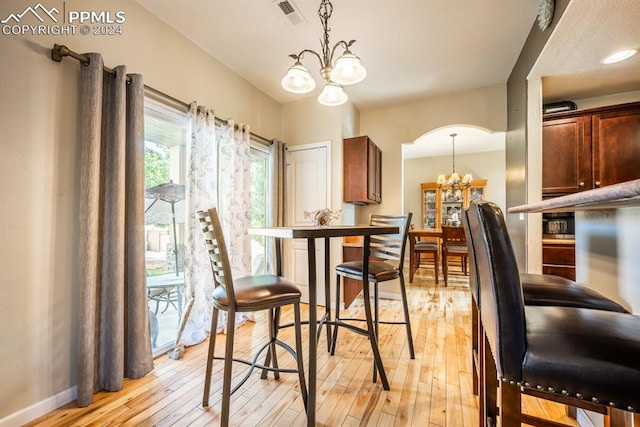 dining area featuring light wood-type flooring and a chandelier