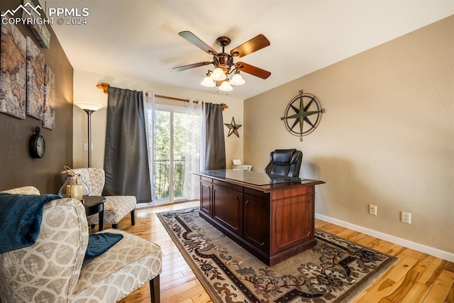 home office with light wood-type flooring and ceiling fan