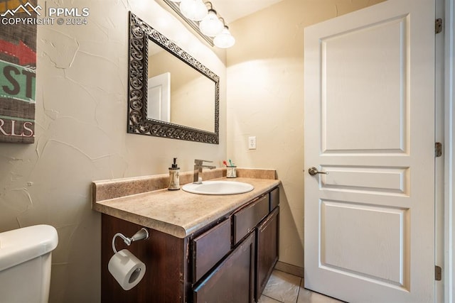 bathroom with tile patterned flooring, vanity, and toilet