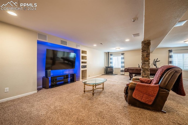 carpeted living room featuring built in shelves, a textured ceiling, and a healthy amount of sunlight