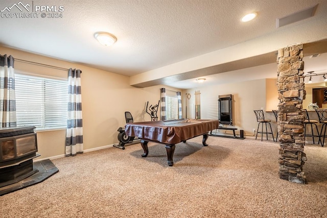 playroom featuring carpet floors, a textured ceiling, pool table, and a wood stove