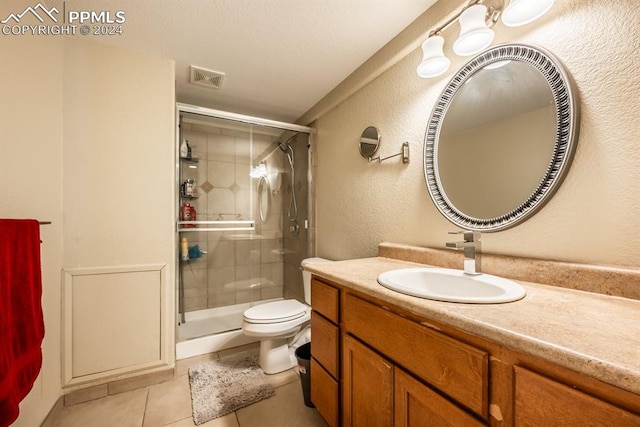 bathroom with tile patterned flooring, vanity, toilet, and an enclosed shower