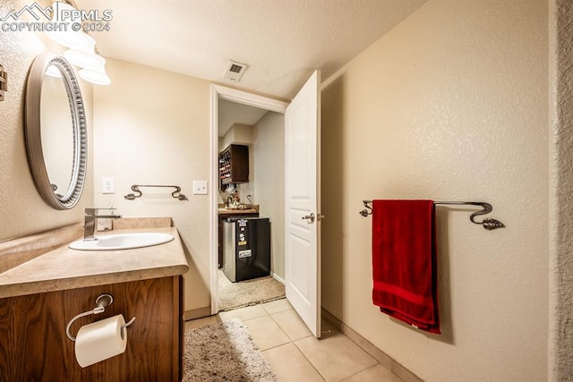 bathroom with vanity, a textured ceiling, and tile patterned floors