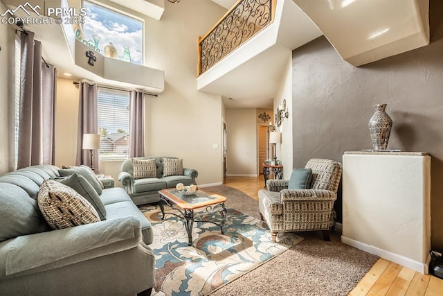 living room with wood-type flooring and a high ceiling