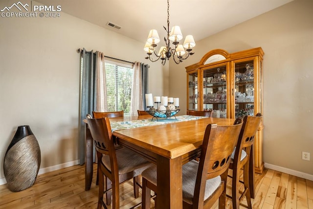 dining space with an inviting chandelier and light wood-type flooring