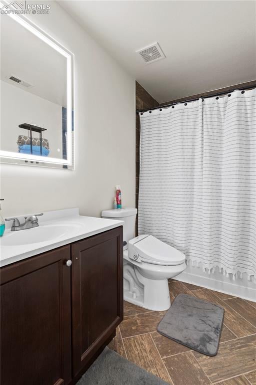 full bathroom with shower / bath combination with curtain, toilet, and vanity