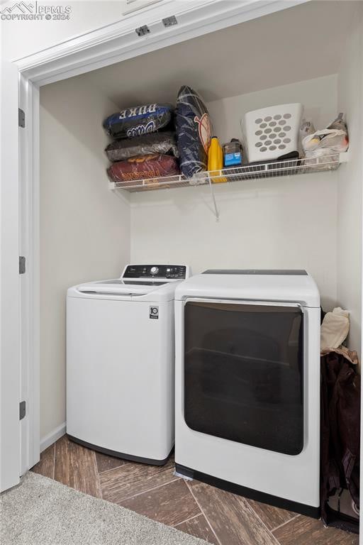 laundry area with washer and dryer and dark hardwood / wood-style flooring