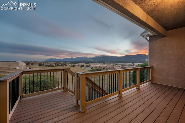 deck at dusk featuring a mountain view