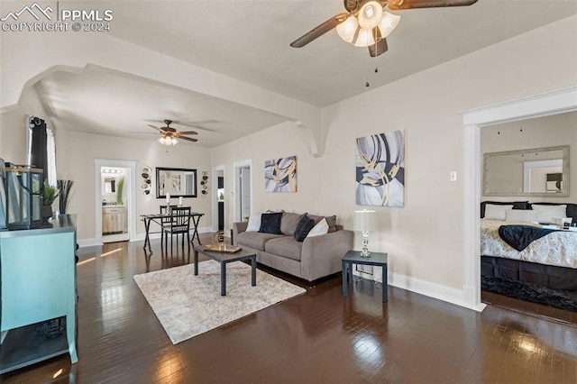 living room with ceiling fan and dark hardwood / wood-style flooring