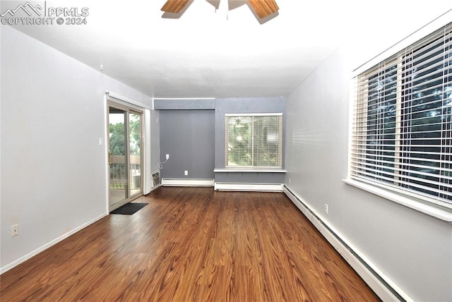 unfurnished room featuring baseboard heating, dark wood-type flooring, and ceiling fan