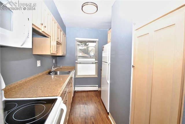 kitchen with stove, sink, a baseboard heating unit, dark hardwood / wood-style floors, and white fridge