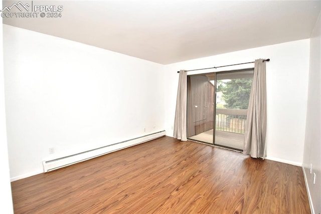 unfurnished room with hardwood / wood-style floors and a baseboard radiator