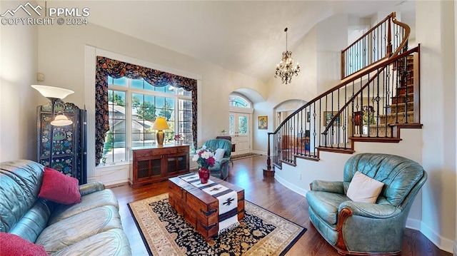 living room featuring an inviting chandelier, lofted ceiling, and hardwood / wood-style flooring