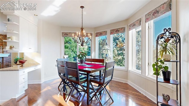 dining space with dark wood-type flooring and a chandelier