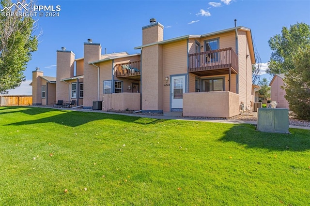 back of house featuring a lawn, cooling unit, and a balcony