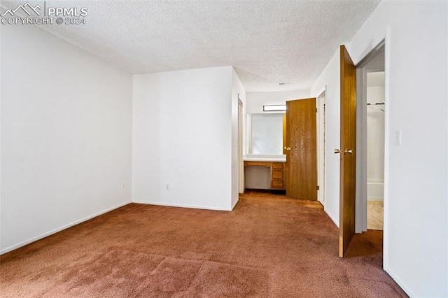 unfurnished bedroom with a textured ceiling and carpet