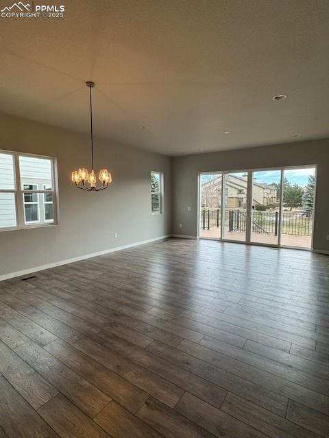 empty room featuring dark hardwood / wood-style floors and a chandelier