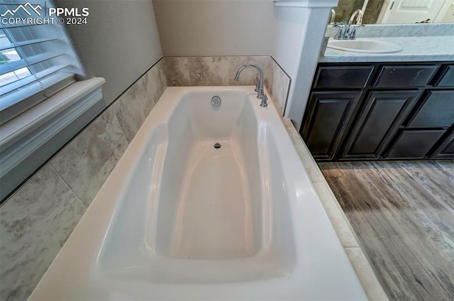 bathroom featuring a tub to relax in, hardwood / wood-style floors, and vanity