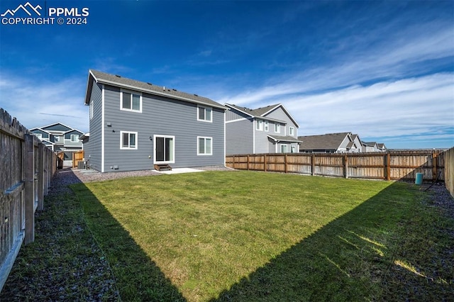 rear view of property featuring a lawn and a patio area