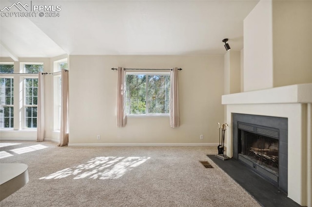 unfurnished living room with carpet flooring and lofted ceiling