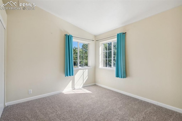 empty room with light carpet and lofted ceiling