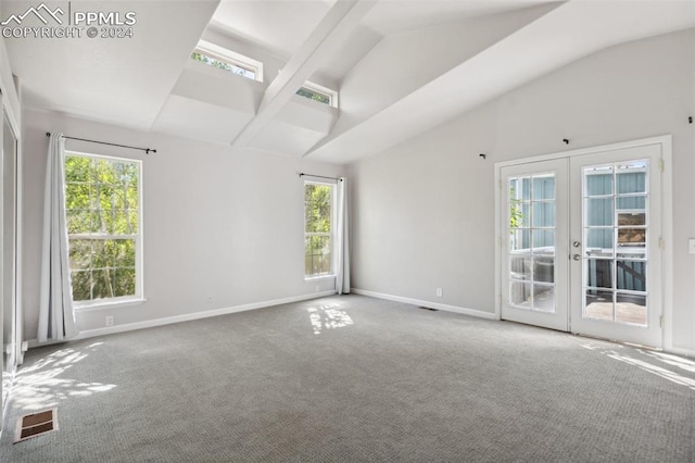 carpeted empty room featuring vaulted ceiling with beams, plenty of natural light, and french doors