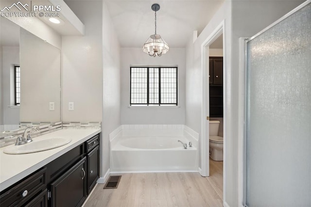 full bathroom with backsplash, vanity, separate shower and tub, hardwood / wood-style flooring, and toilet