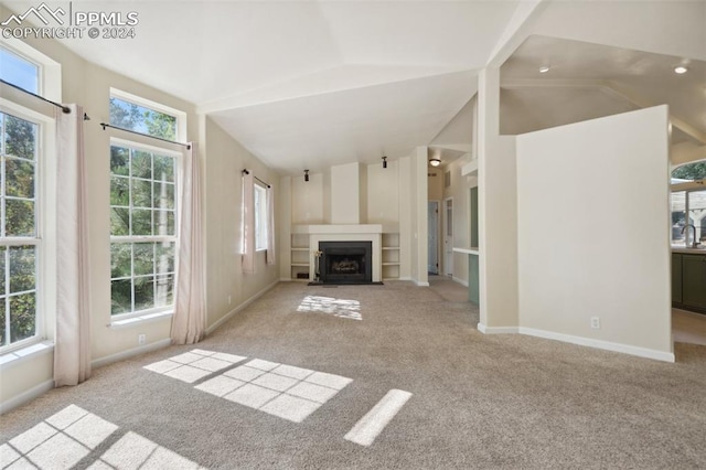 unfurnished living room featuring light carpet and vaulted ceiling