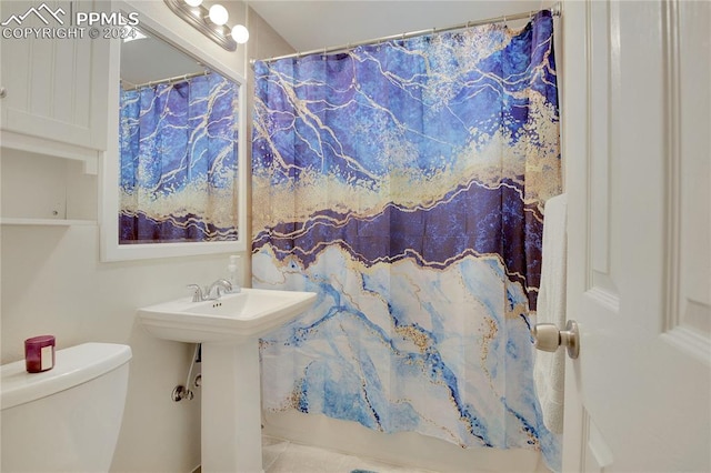 full bathroom featuring sink, shower / tub combo, and toilet