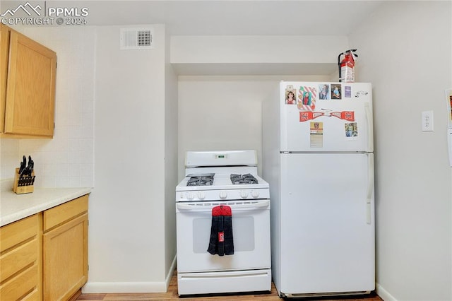 kitchen with decorative backsplash, light wood-type flooring, white appliances, and light brown cabinetry