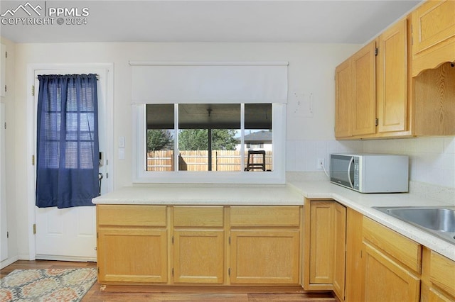 kitchen featuring light brown cabinets, backsplash, and light hardwood / wood-style floors