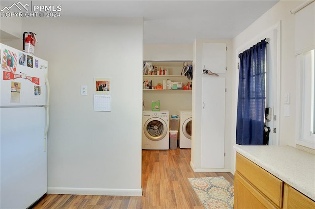 laundry area featuring separate washer and dryer and light hardwood / wood-style flooring