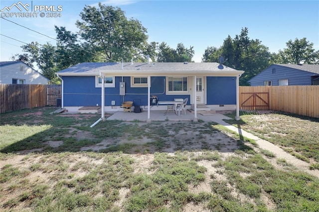 rear view of property with a yard and a patio area