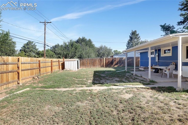 view of yard featuring a storage unit and a patio area