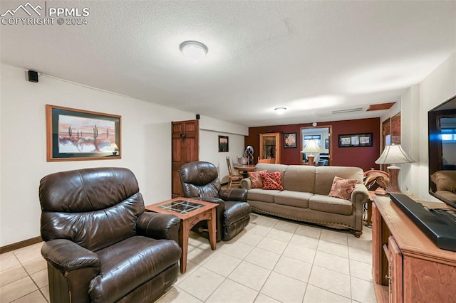 tiled living room featuring a textured ceiling