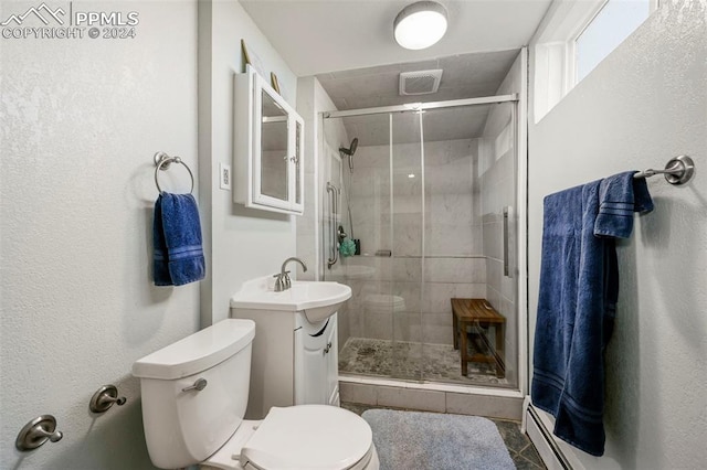 bathroom featuring vanity, toilet, a shower with door, and a baseboard heating unit