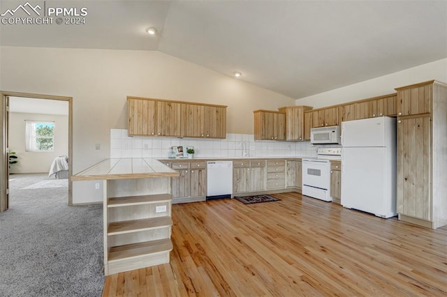 kitchen with light wood-type flooring, lofted ceiling, decorative backsplash, white appliances, and tile countertops