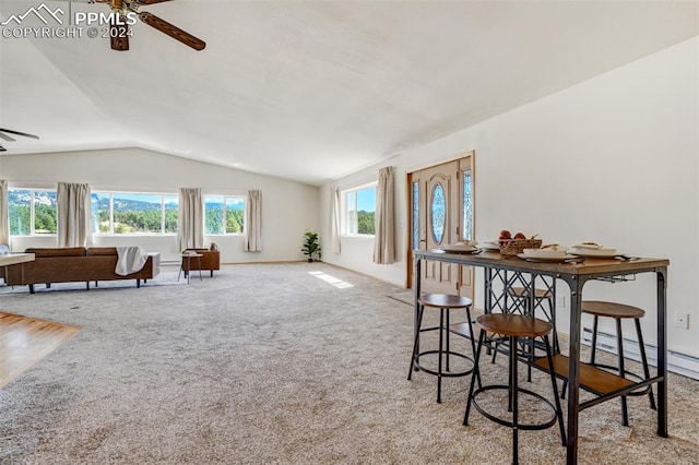 carpeted dining room featuring lofted ceiling, ceiling fan, and a baseboard radiator