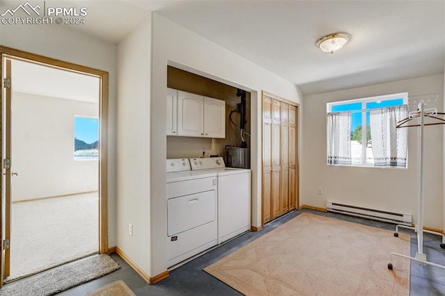 clothes washing area with cabinets, washer and dryer, and a baseboard radiator