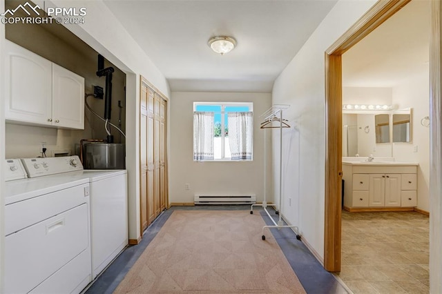 washroom featuring cabinets, sink, washing machine and clothes dryer, and a baseboard radiator