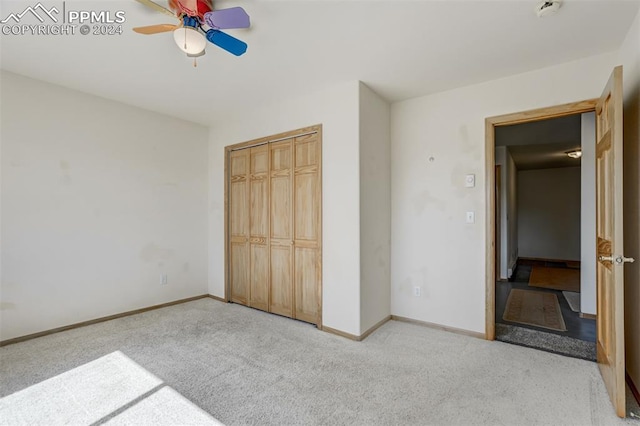 unfurnished bedroom with ceiling fan, light colored carpet, and a closet