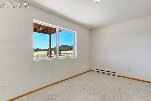 carpeted empty room with a mountain view and a baseboard radiator