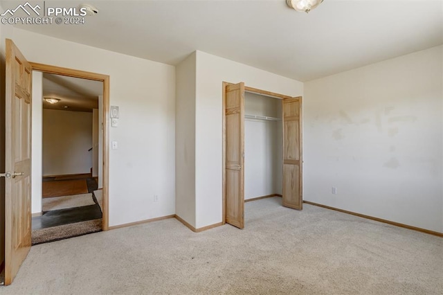 unfurnished bedroom with a closet and light colored carpet