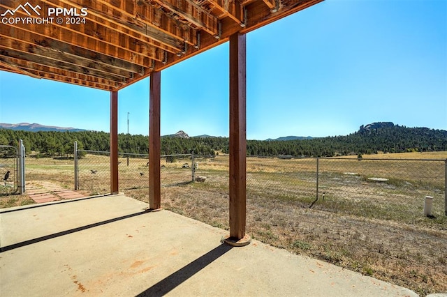 view of patio / terrace with a mountain view and a rural view